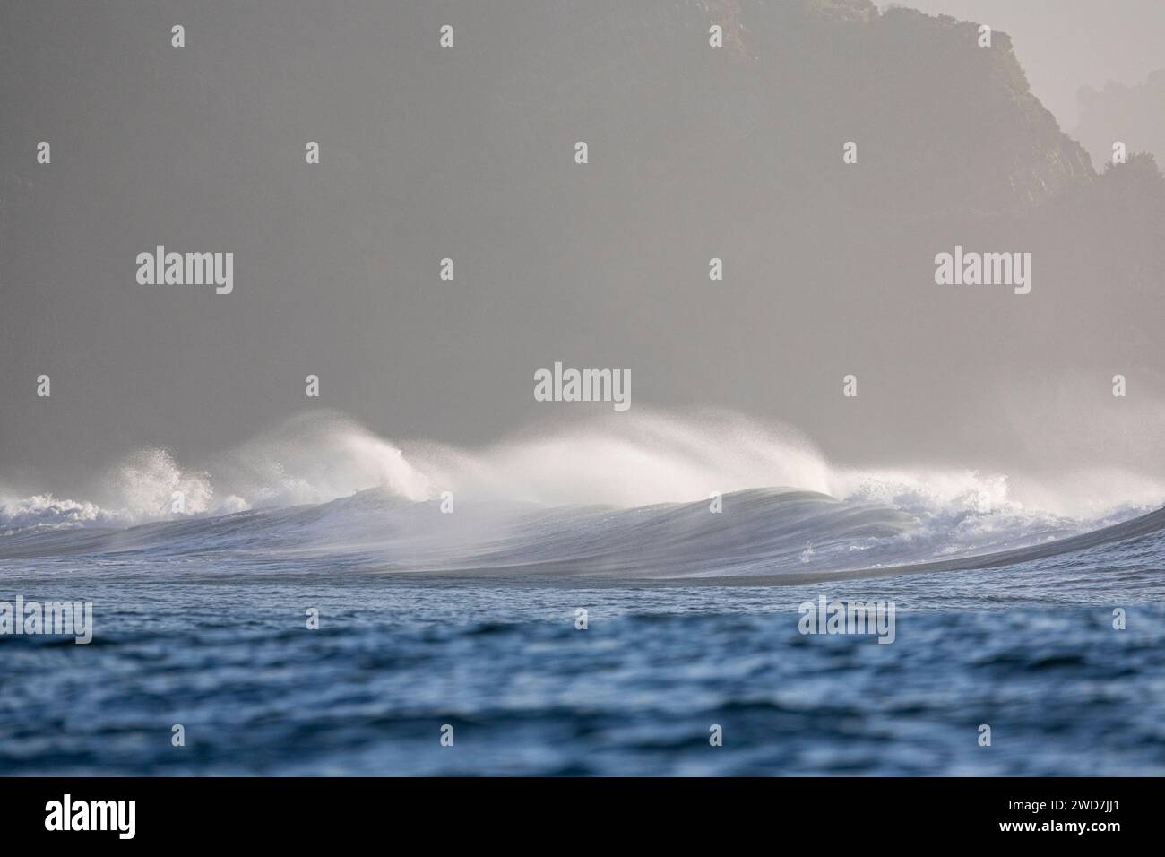 Waves breaking with the coast as a backdrop Stock Photo