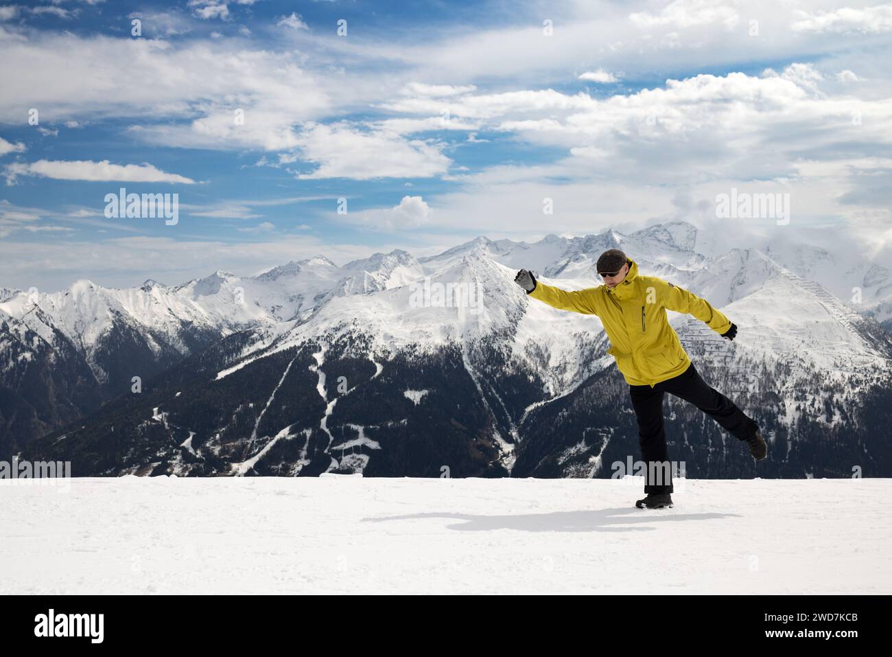Skier simulates ski step. Snow-capped Alps. Mountain, blue sky, clouds ...