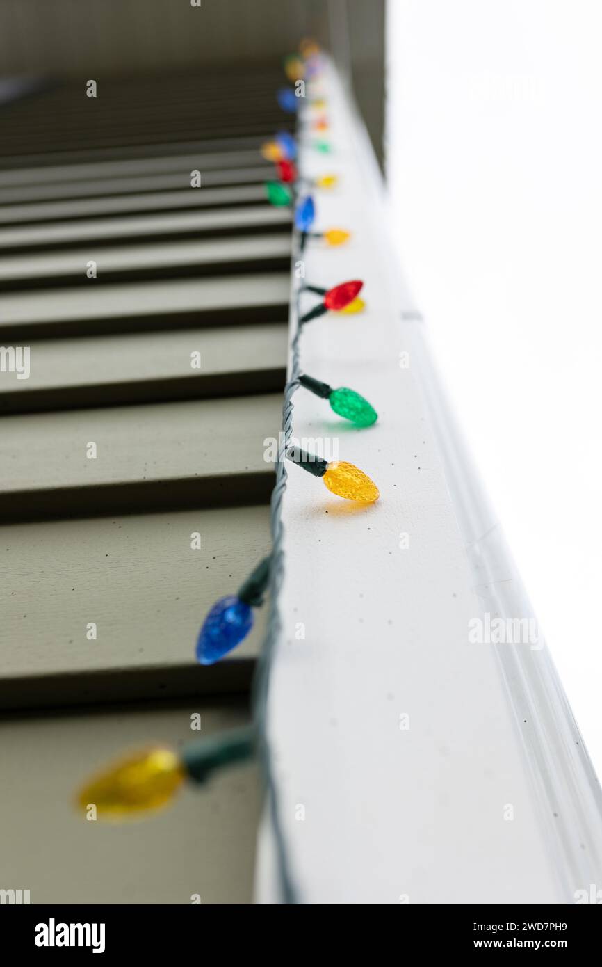string of Christmas lights against a the side of a house Stock Photo
