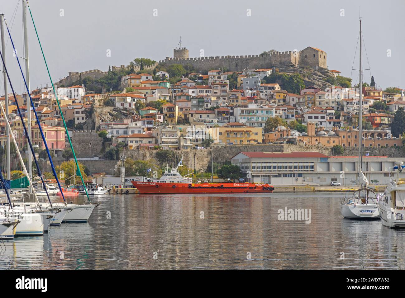 Kavala, Greece - October 22, 2023: Sailboats and Ship Moored at Port of Kavala at Calm Autumn Day. Stock Photo