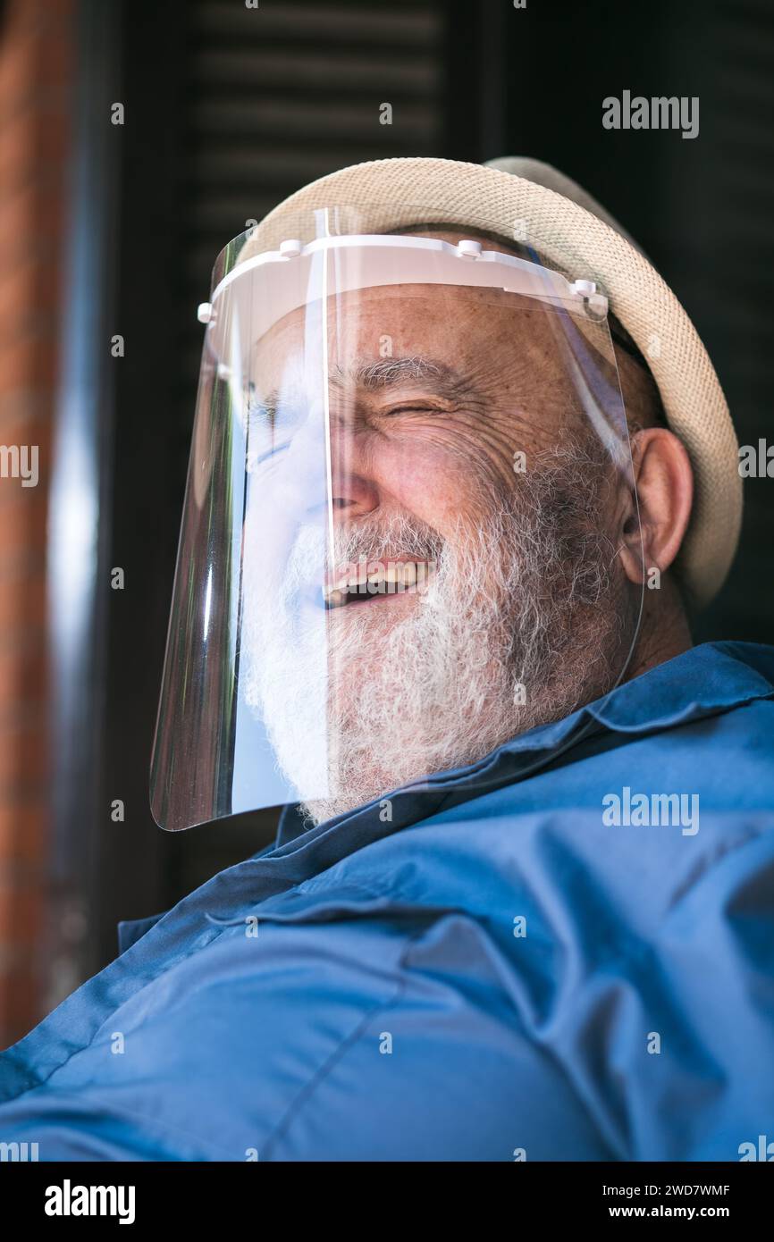 elderly man smiling under a protective visor Stock Photo