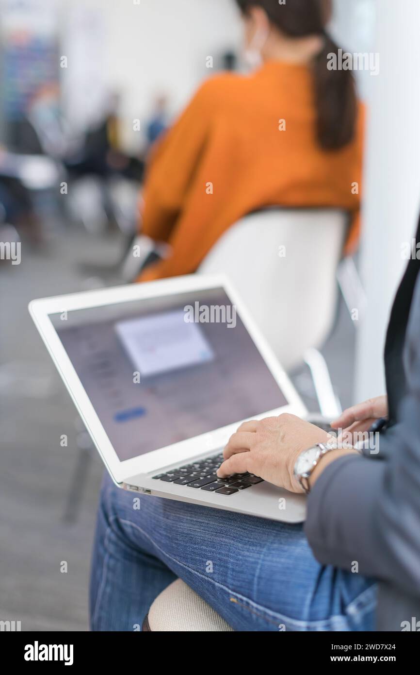 woman using a laptop taking notes during a seminar presentation Stock Photo