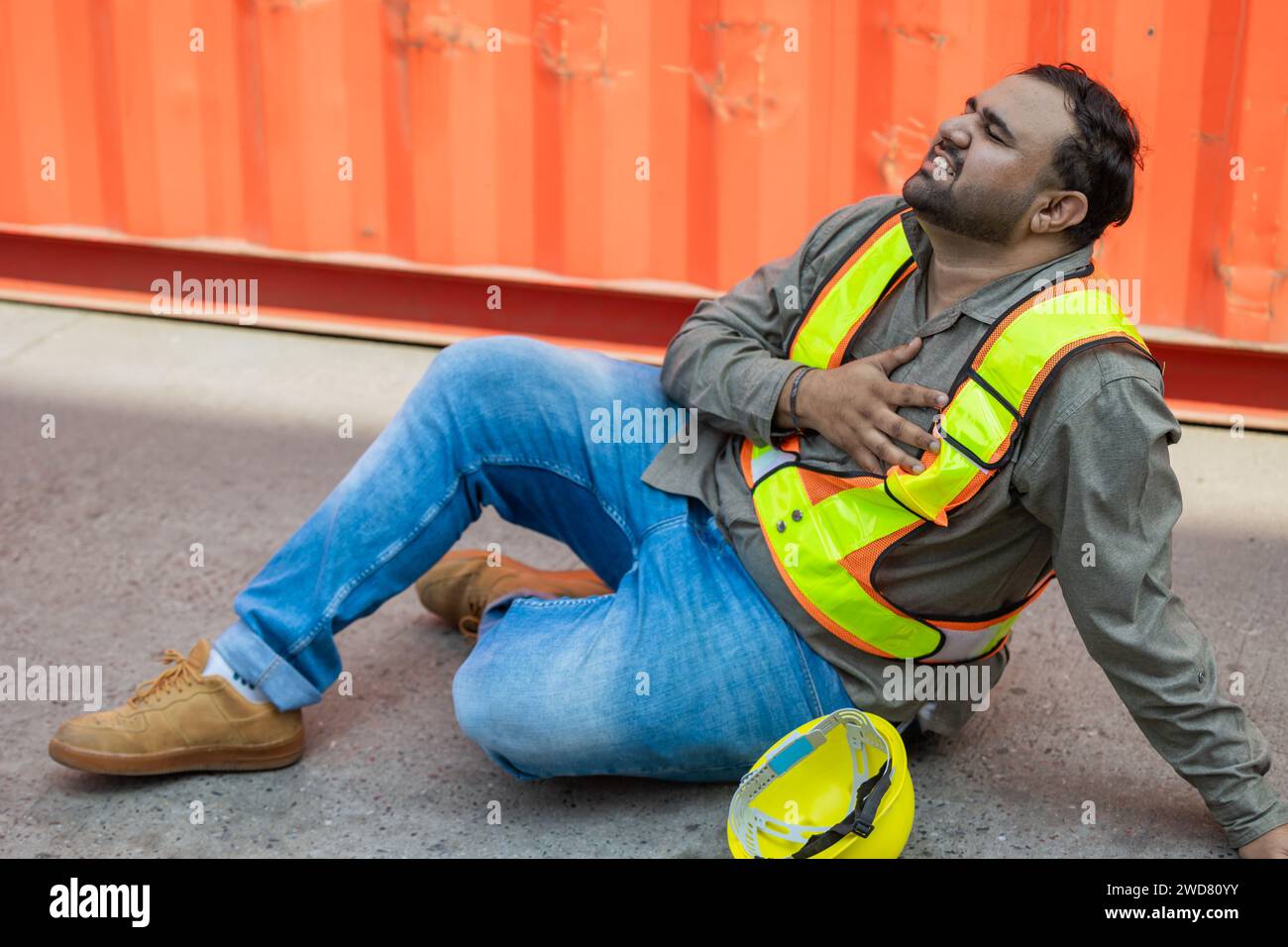 Heart attack chest pain expression. Hispanic indian fat male worker industry engineer staff accident fall down injury emergency need medical Stock Photo