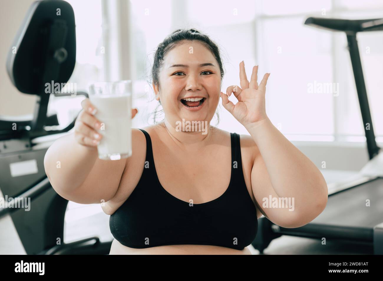 sport healthy fat women happy smiling enjoy drink milk and diet exercise activity in fitness sport club Stock Photo