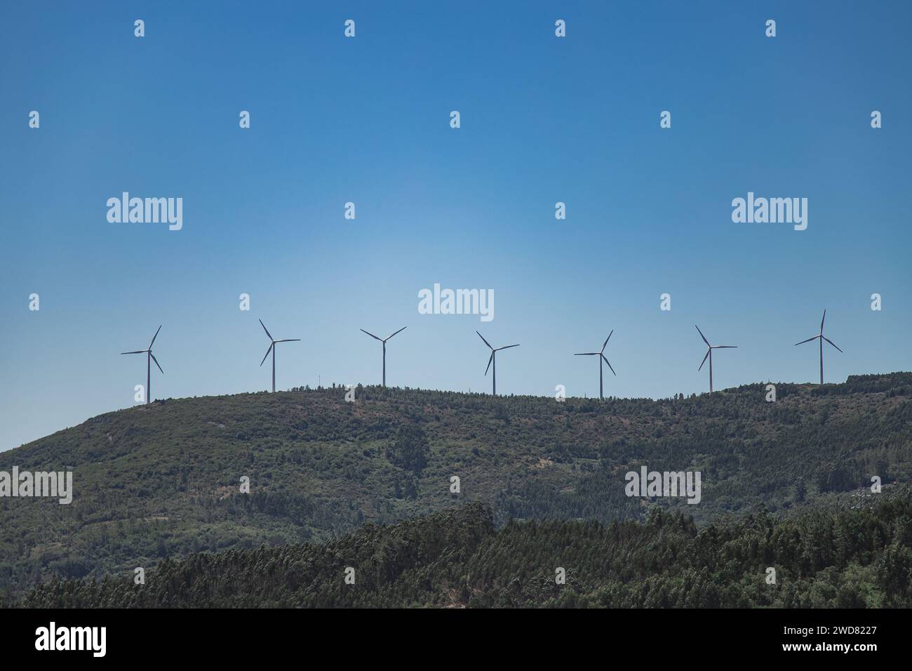 Mountainous landscape with wind turbines on top of the mountains on a ...