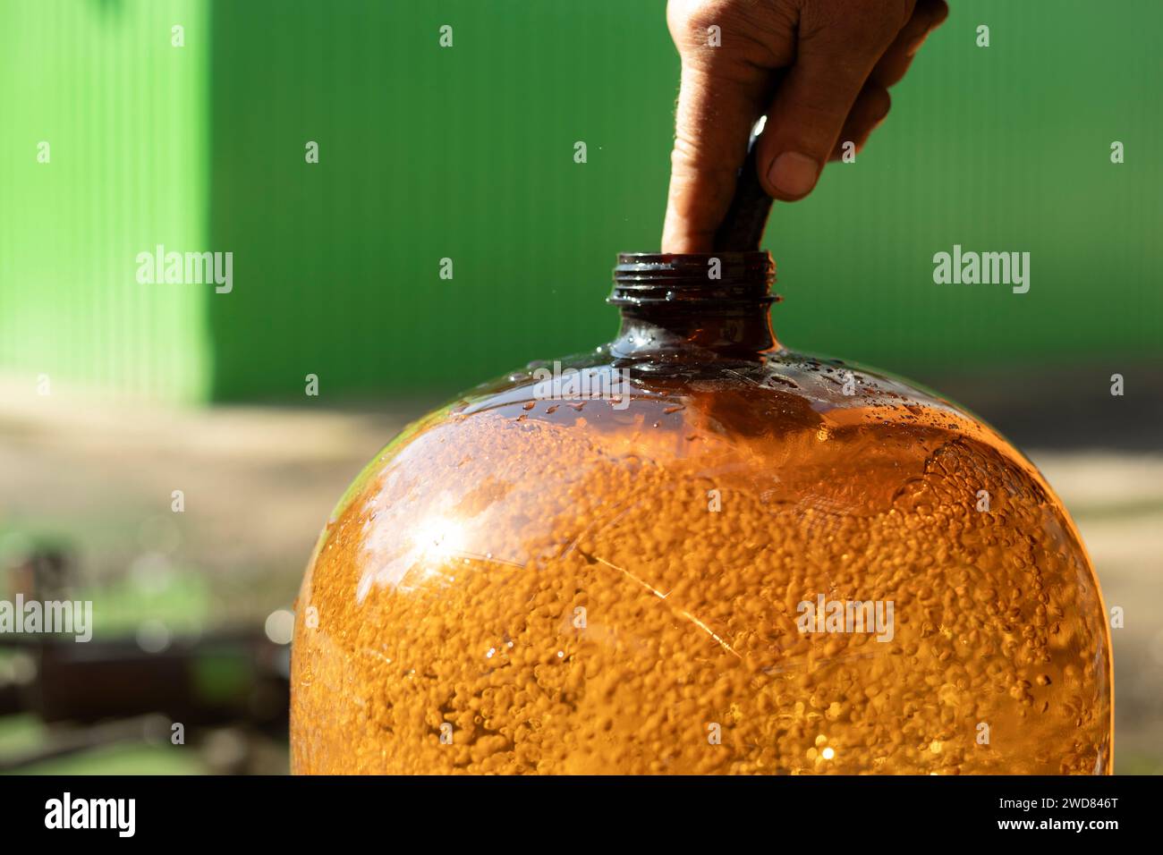 Filling the canister with water. Large plastic bottle. Air bubbles in