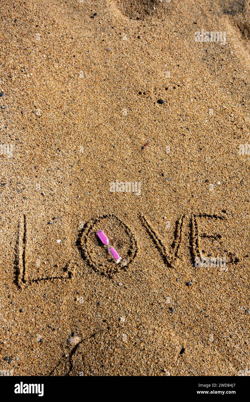 Timeless love 'Love' inscribed on the beach, cradling a pinkhued