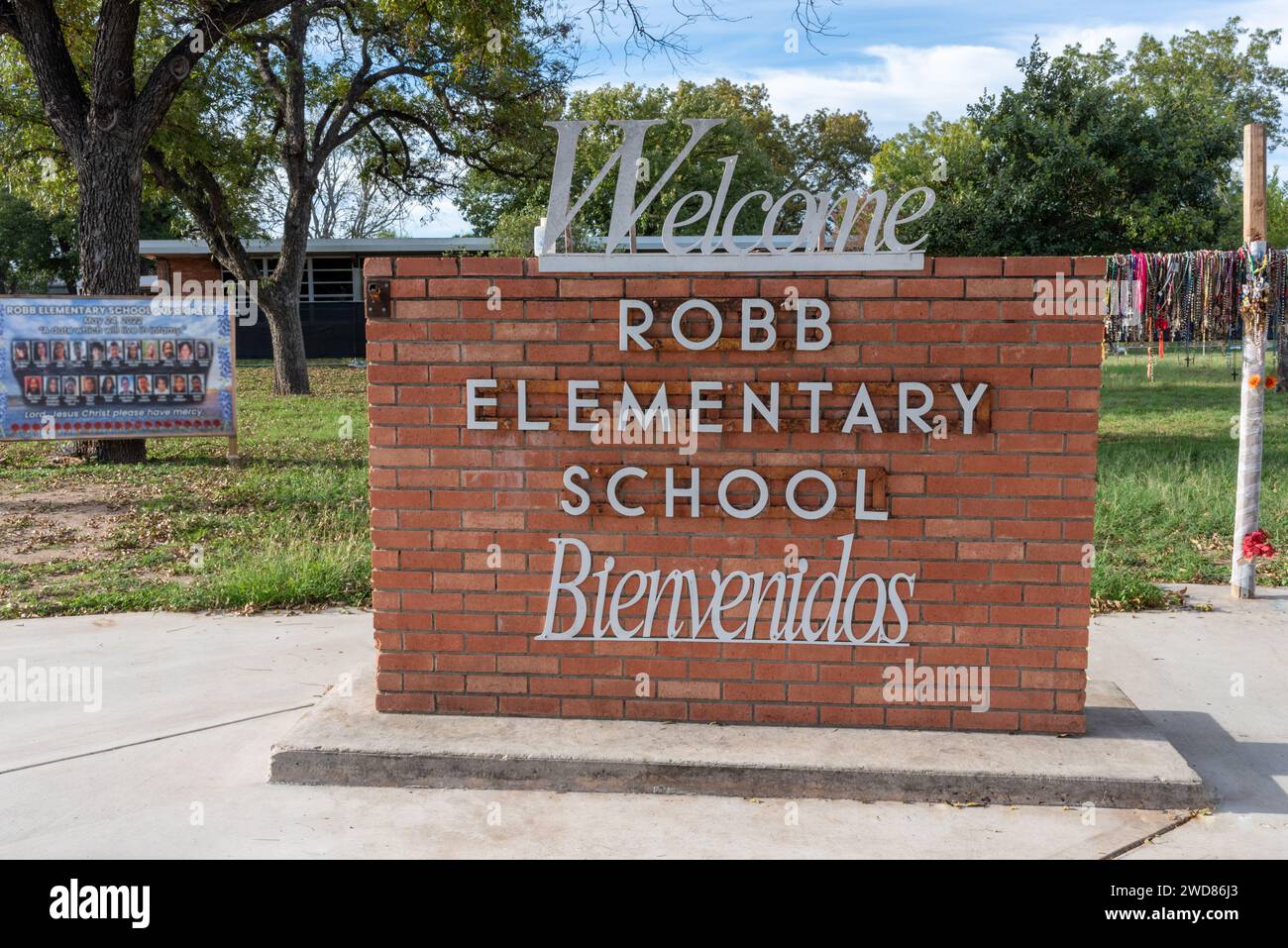 Welcome sign in front of Robb Elementary School, memorial in background in tribute to victims of tragic school shooting, Uvalde, Texas, USA. Stock Photo