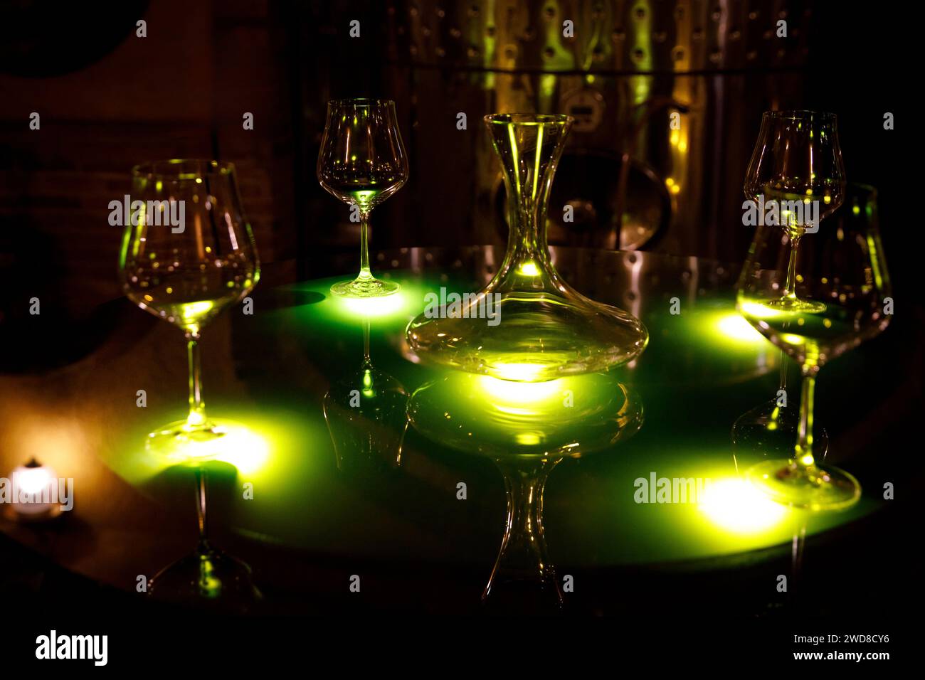 Set of elegant wine glasses and a decanter, illuminated by an enigmatic