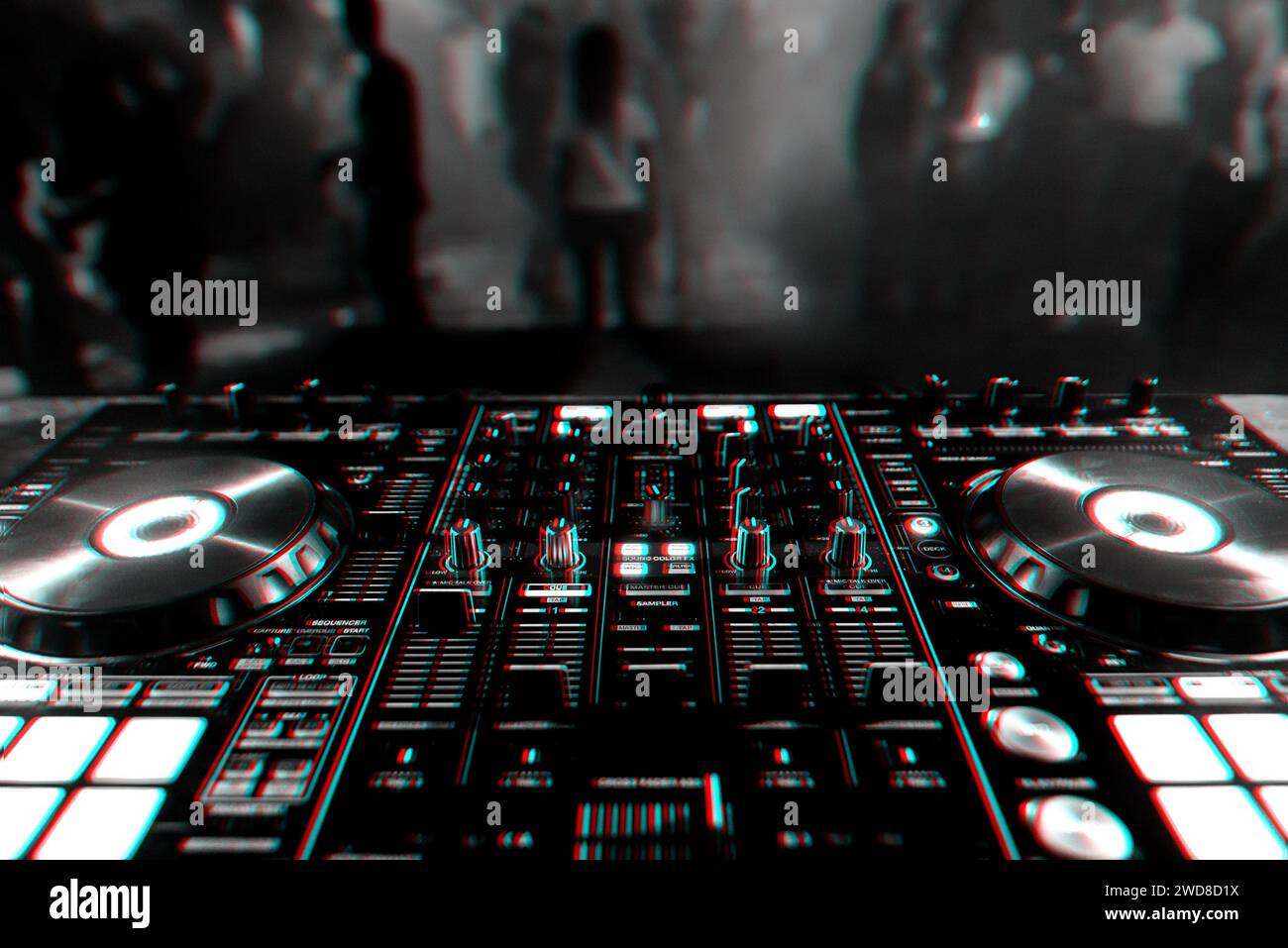 DJ mixer controller Board for professional mixing of electronic music in a nightclub at a party with dancing people in the background. Black and white Stock Photo