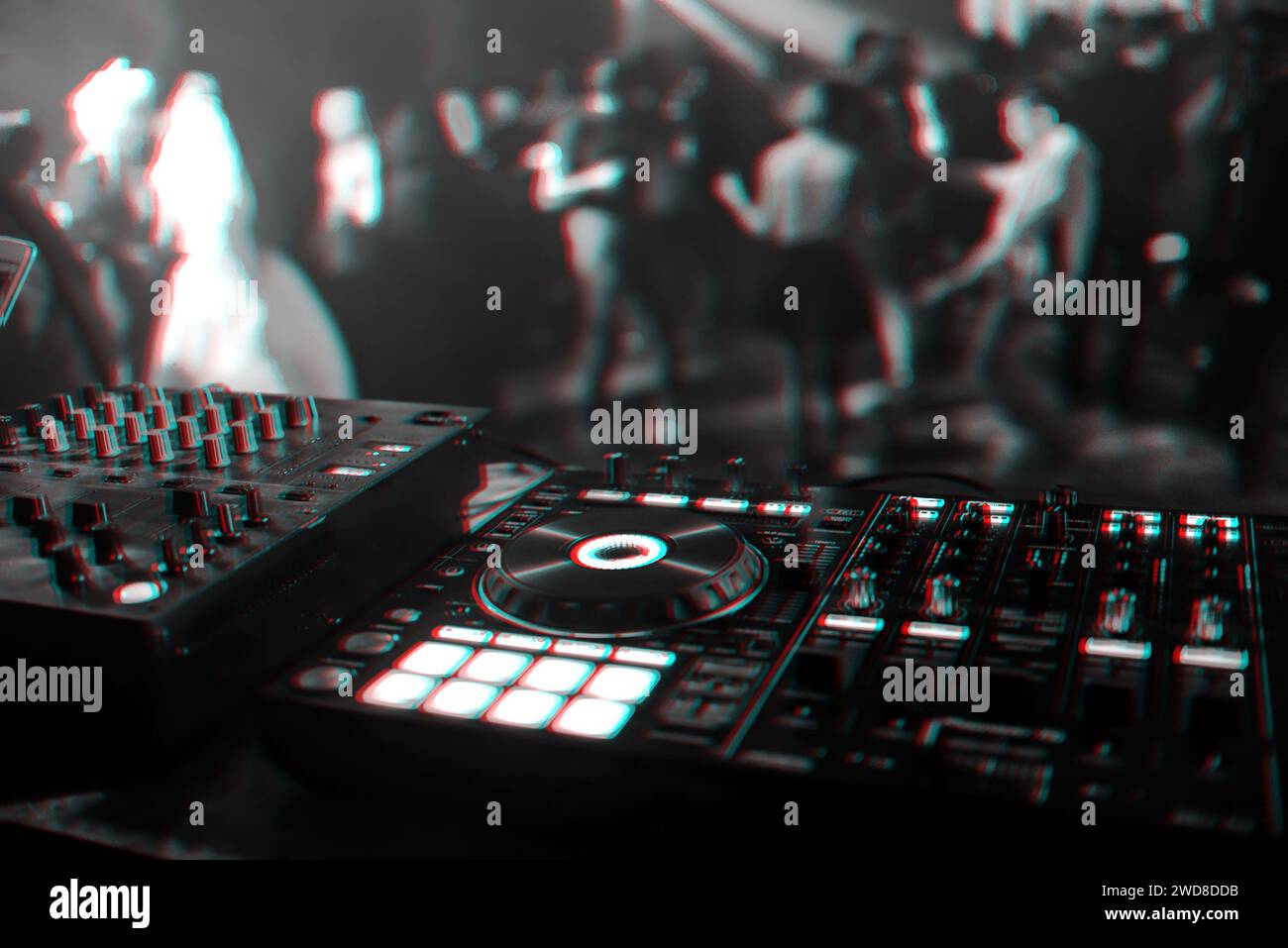 control DJ for mixing music with blurred people dancing at a party in a nightclub. Black and white photo with glitch effect and small grain Stock Photo