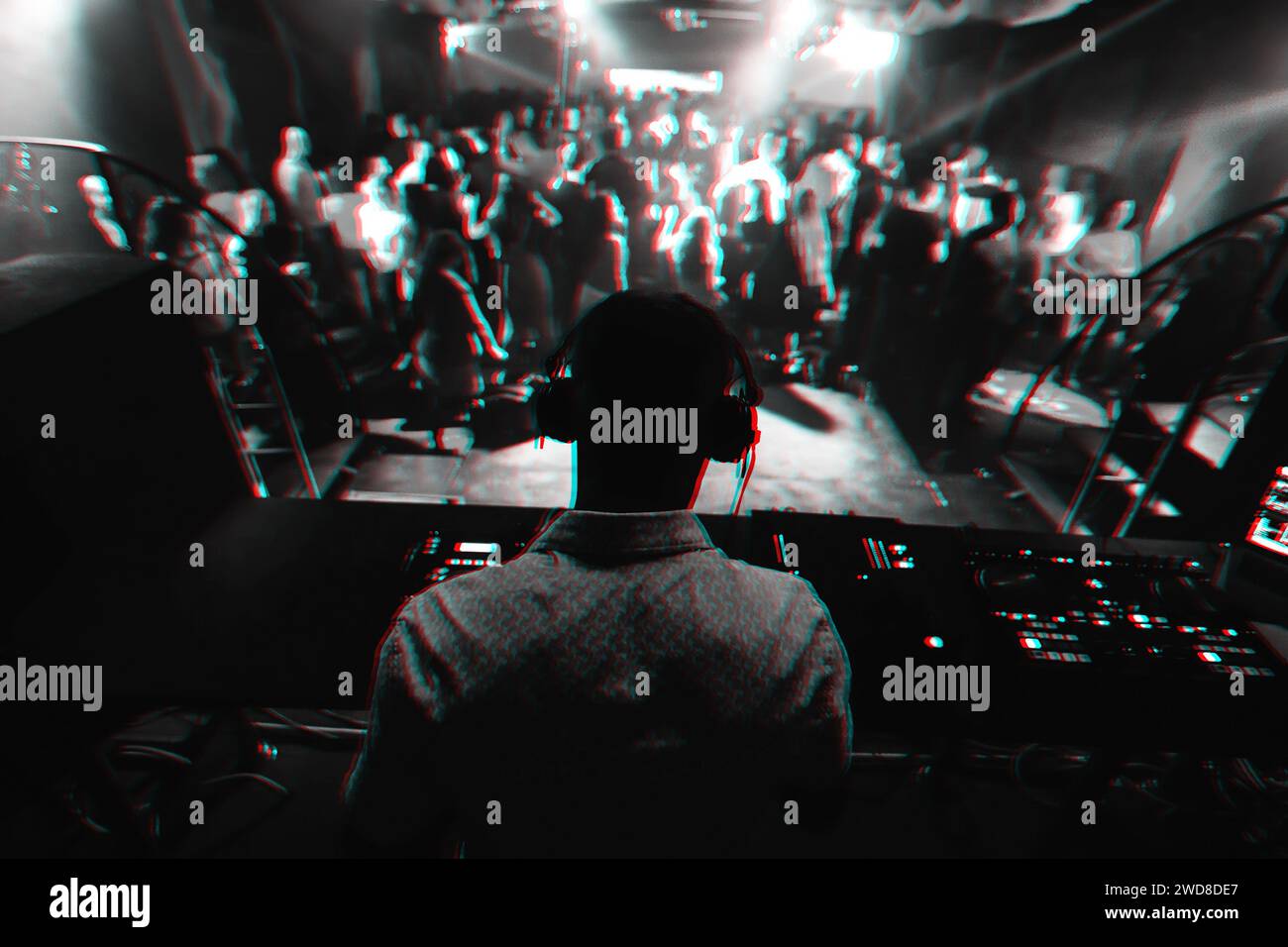 silhouette of a DJ playing music on the mixer and a lot of people dancing in a nightclub on stage. Black and white photo with glitch effect and small Stock Photo
