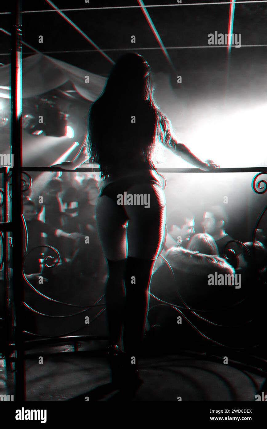 silhouette of a girl go-go dancer on stage in a nightclub. Black and white photo with glitch effect and small grain Stock Photo