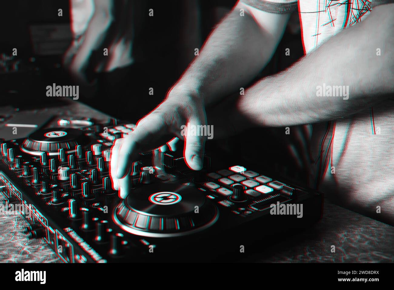 hands of the DJ on the background of the mixer in the nightclub at a party. Black and white photo with glitch effect and small grain Stock Photo