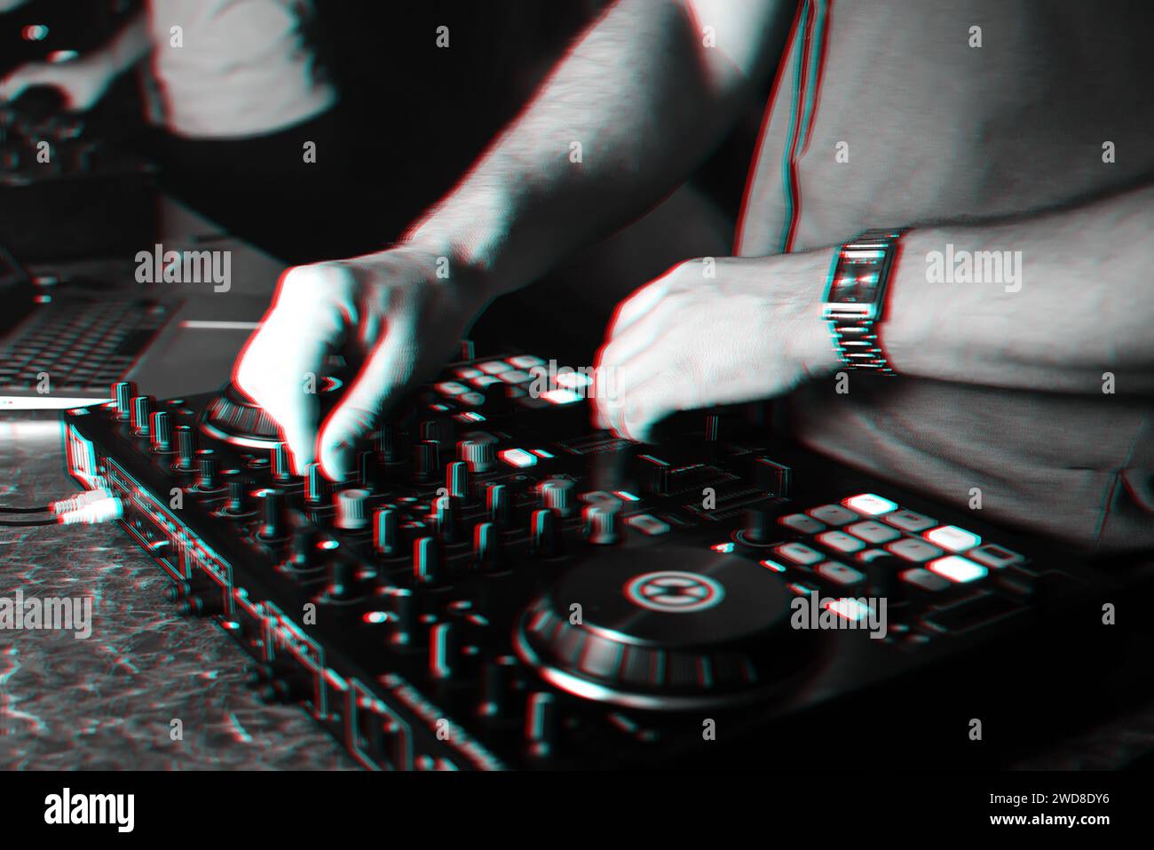 hands of a DJ in a booth playing on the mixer in the club. Black and white photo with glitch effect and small grain Stock Photo