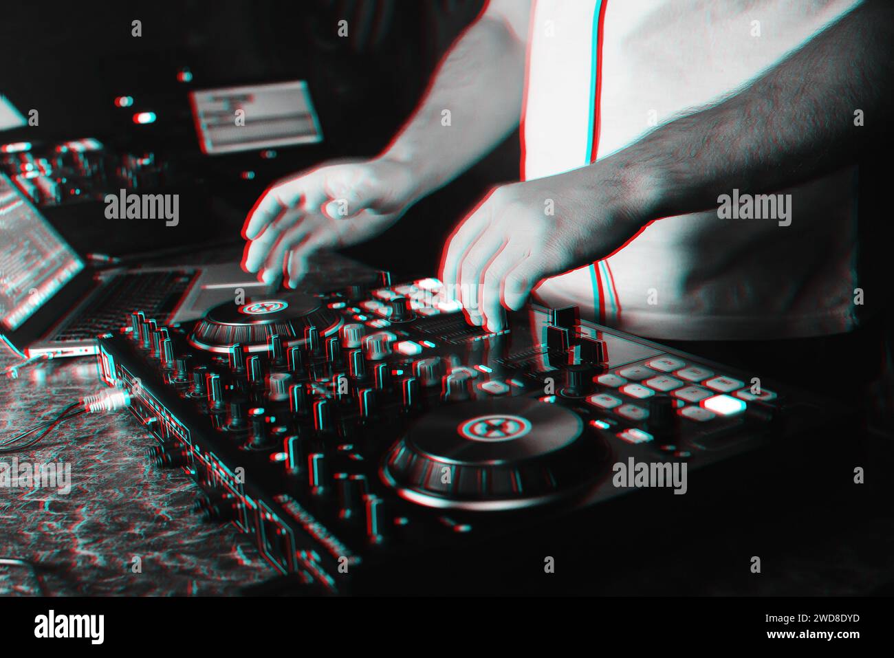 DJ in a booth playing a mixer at a nightclub at a party. Black and white photo with glitch effect and small grain Stock Photo
