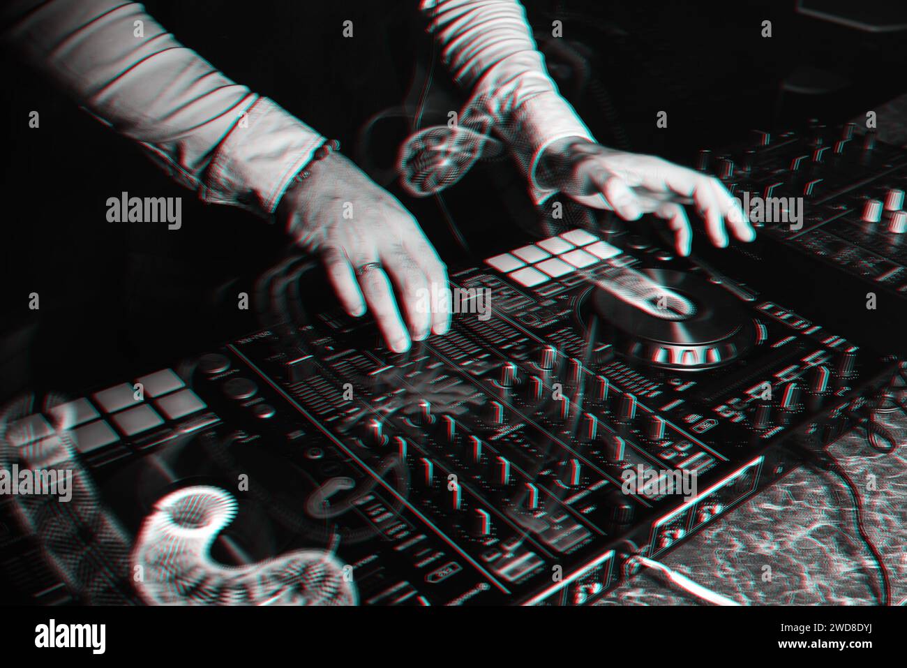 DJ plays with his hands on a music mixer in a nightclub. Black and white photo with glitch effect and small grain Stock Photo