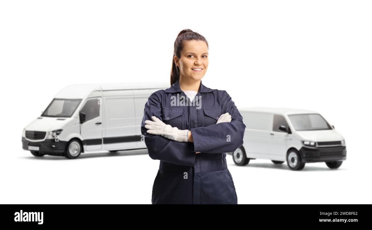 Young female mechanic worker in an overall uniform and gloves posing in front of vans isolated on white background Stock Photo
