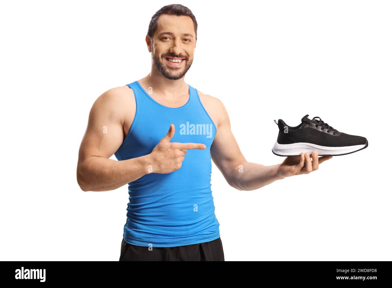 Male athlete holding a trainer sport shoe and pointing isolated on white background Stock Photo