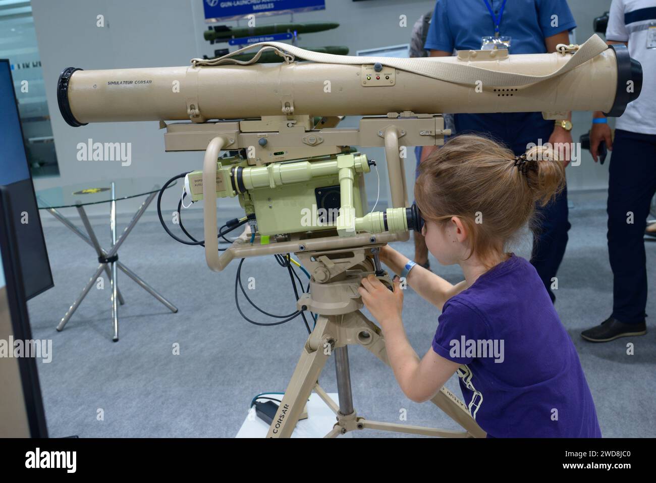 Little girl looking into the eyepiece of the simulator of the anti tank