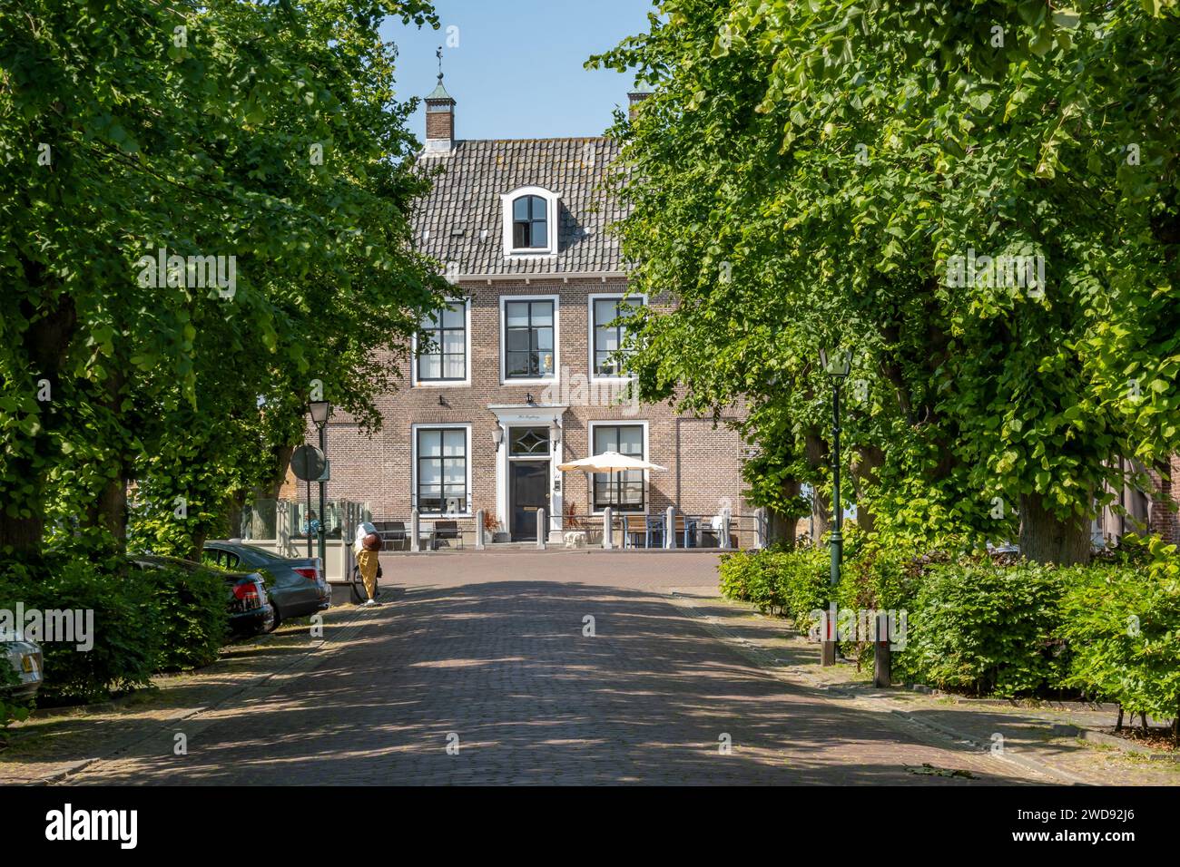 Streetscene with facade of monumental Regthuys in town of Colijnsplaat, Noord-Beveland, Zeeland, Netherlands Stock Photo