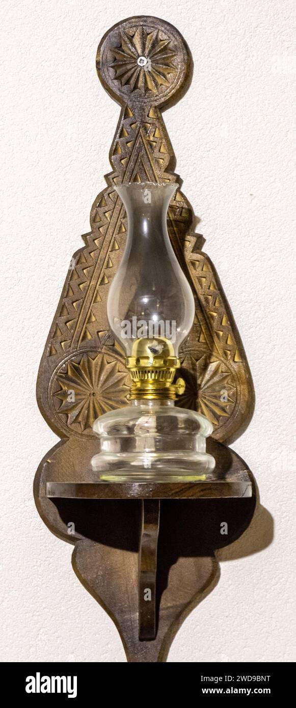 Old oil lamp powered by kerosene hanging on the wall. Isolated white background Stock Photo