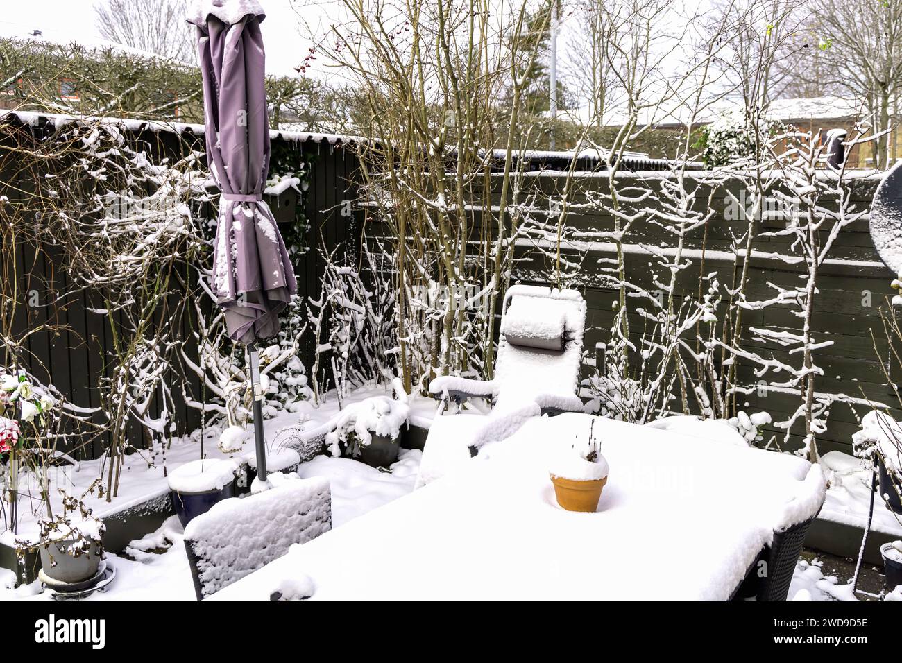 Winter snow-covered garden with garden furniture under the snow. Stock Photo
