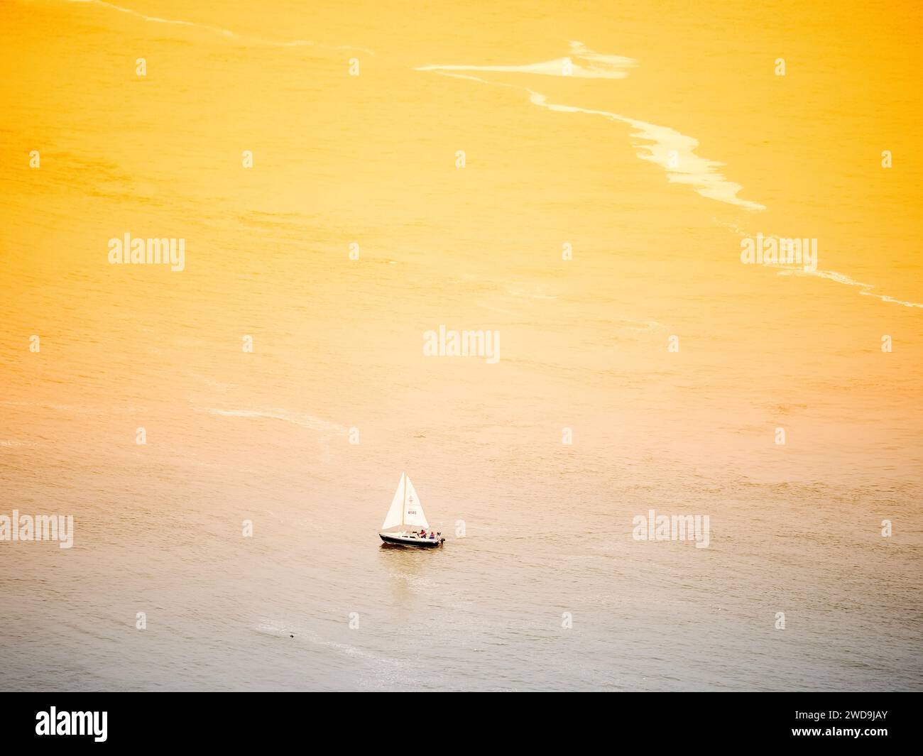 From San Francisco golden gate bridge, sunset shining on ocean surface, a sailboat in the view, Olympus 70-200mm captured this moment. Stock Photo