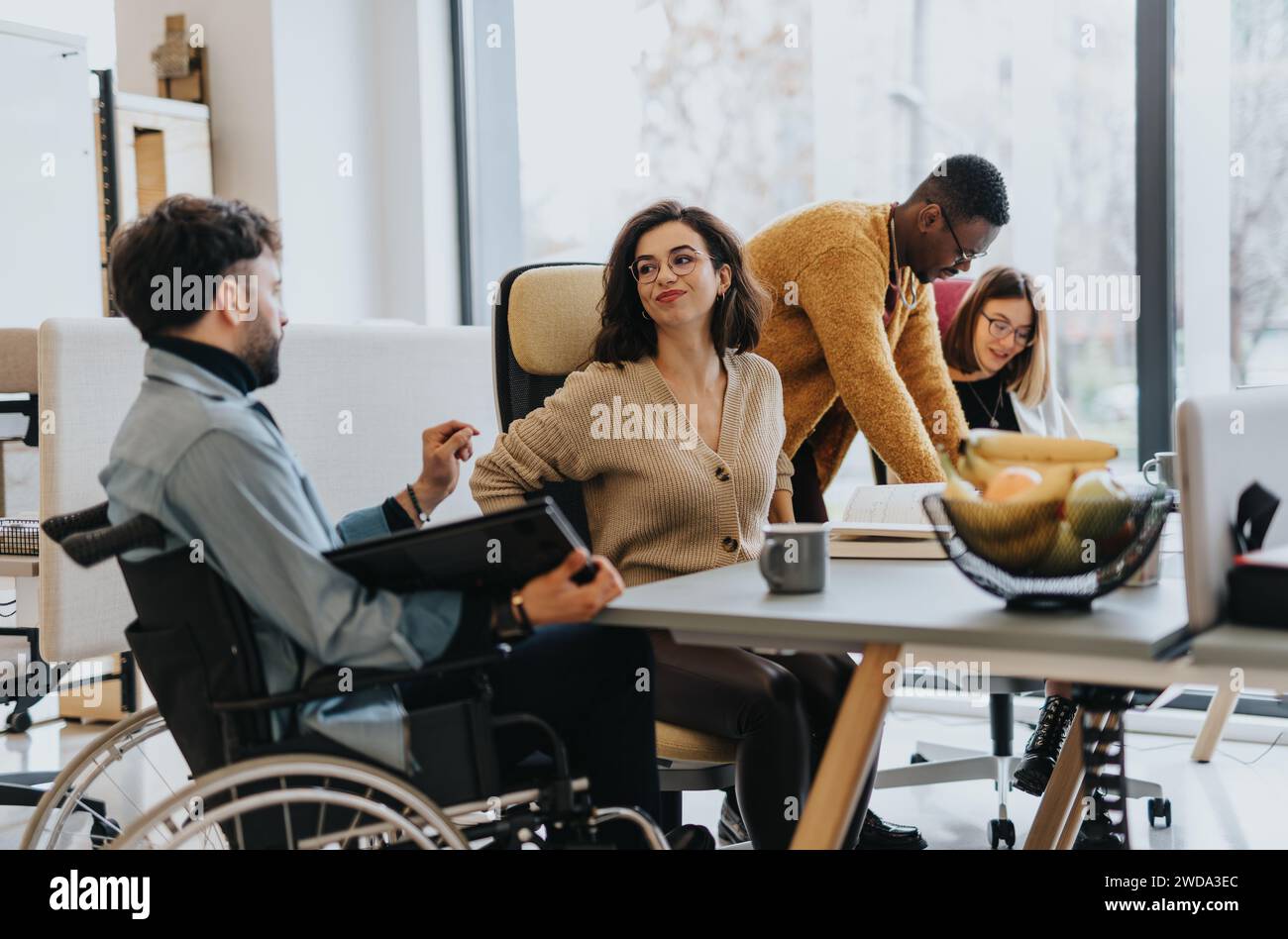 A group of multicultural coworkers collaborating in a creative office. Stock Photo