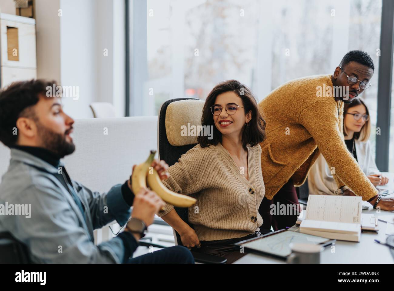 Multicultural team of employees collaborating and discussing reports in creative office Stock Photo