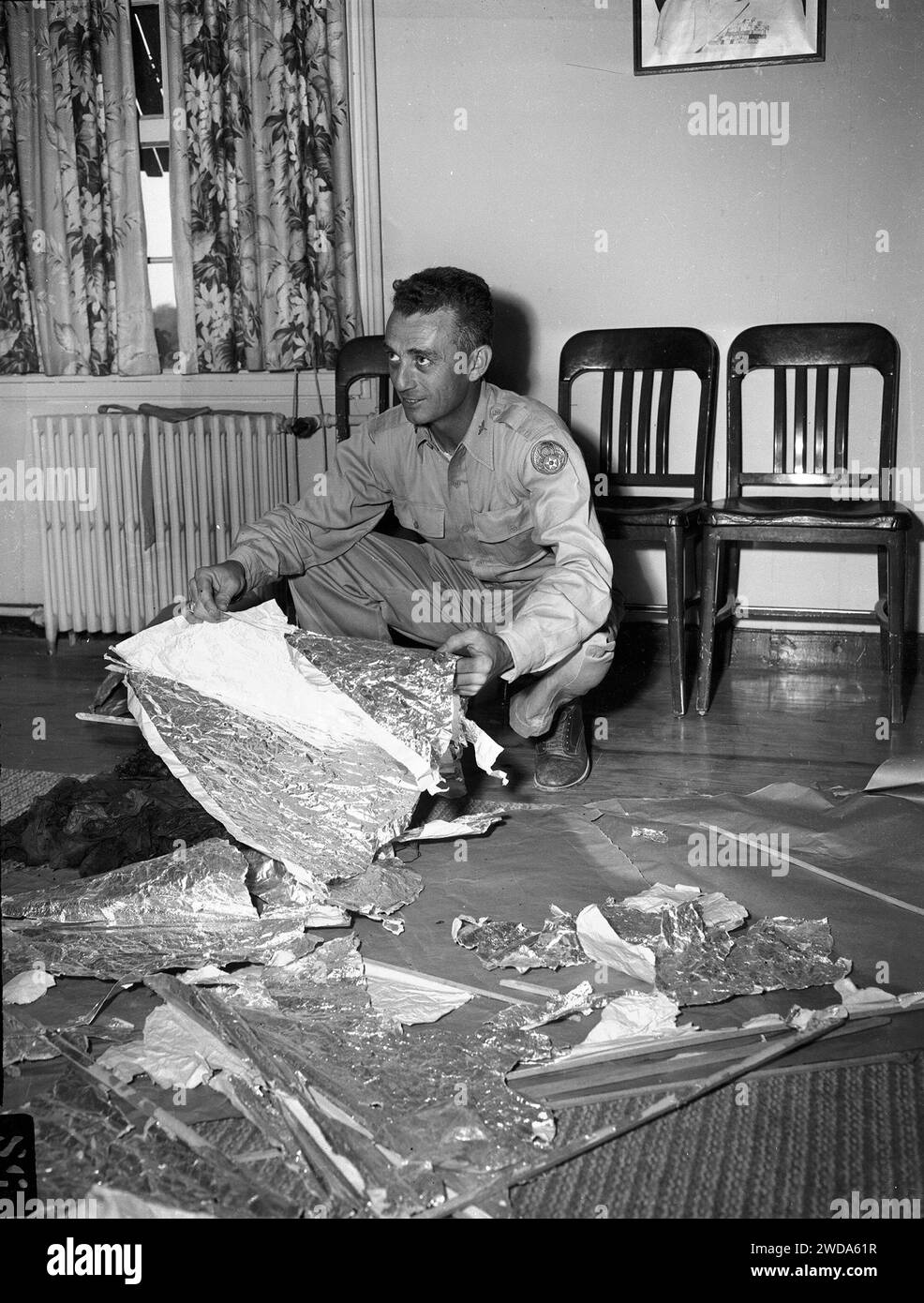 Major Jesse A. Marcel at Fort Worth Army Air Field, holding piece of foil lined material related to Roswell, New Mexico, UFO incident, July 8, 1947. (File Reference # 34580-627THA) Stock Photo
