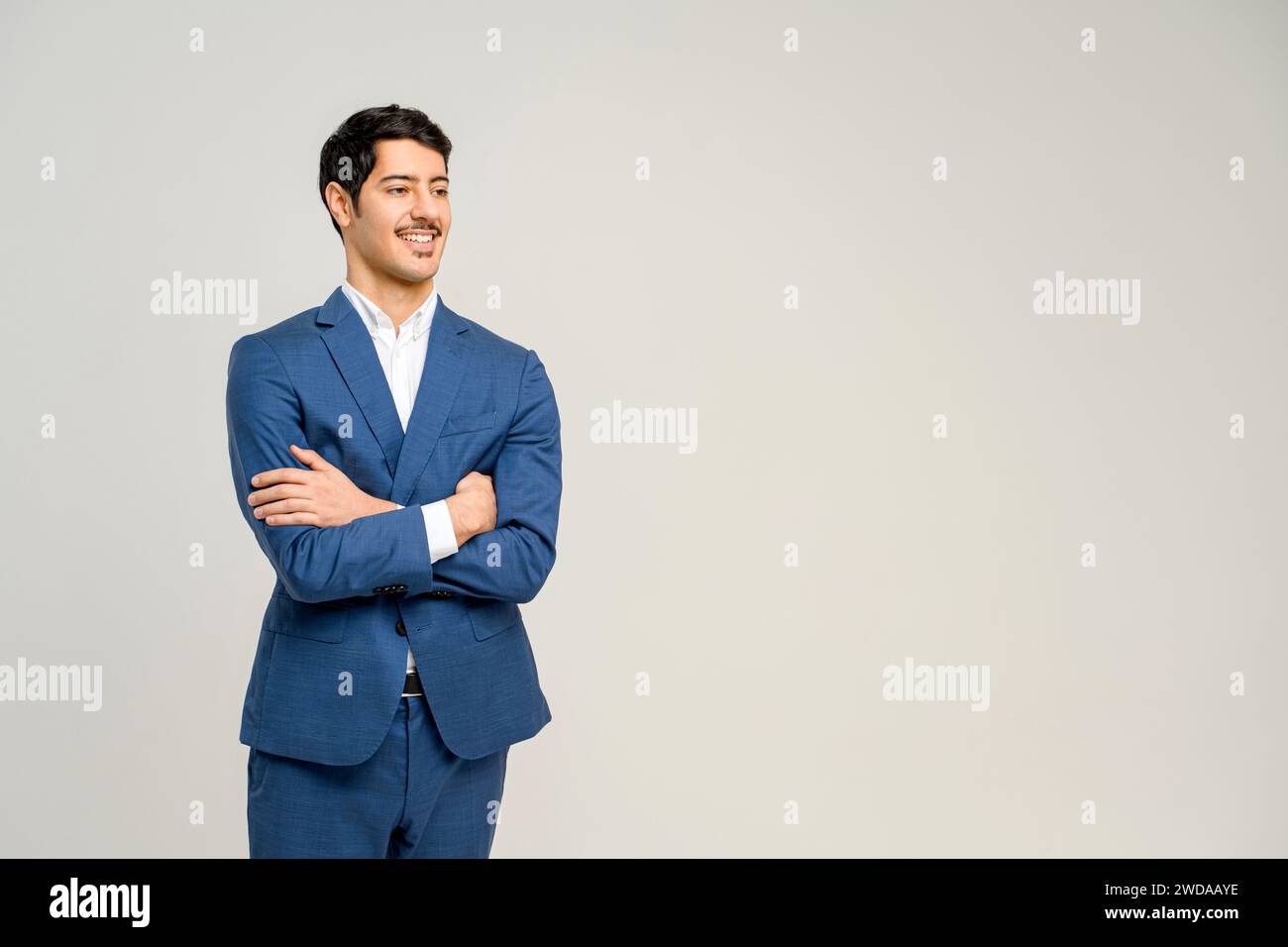 In a striking blue suit young businessman stands with a comfortable ...