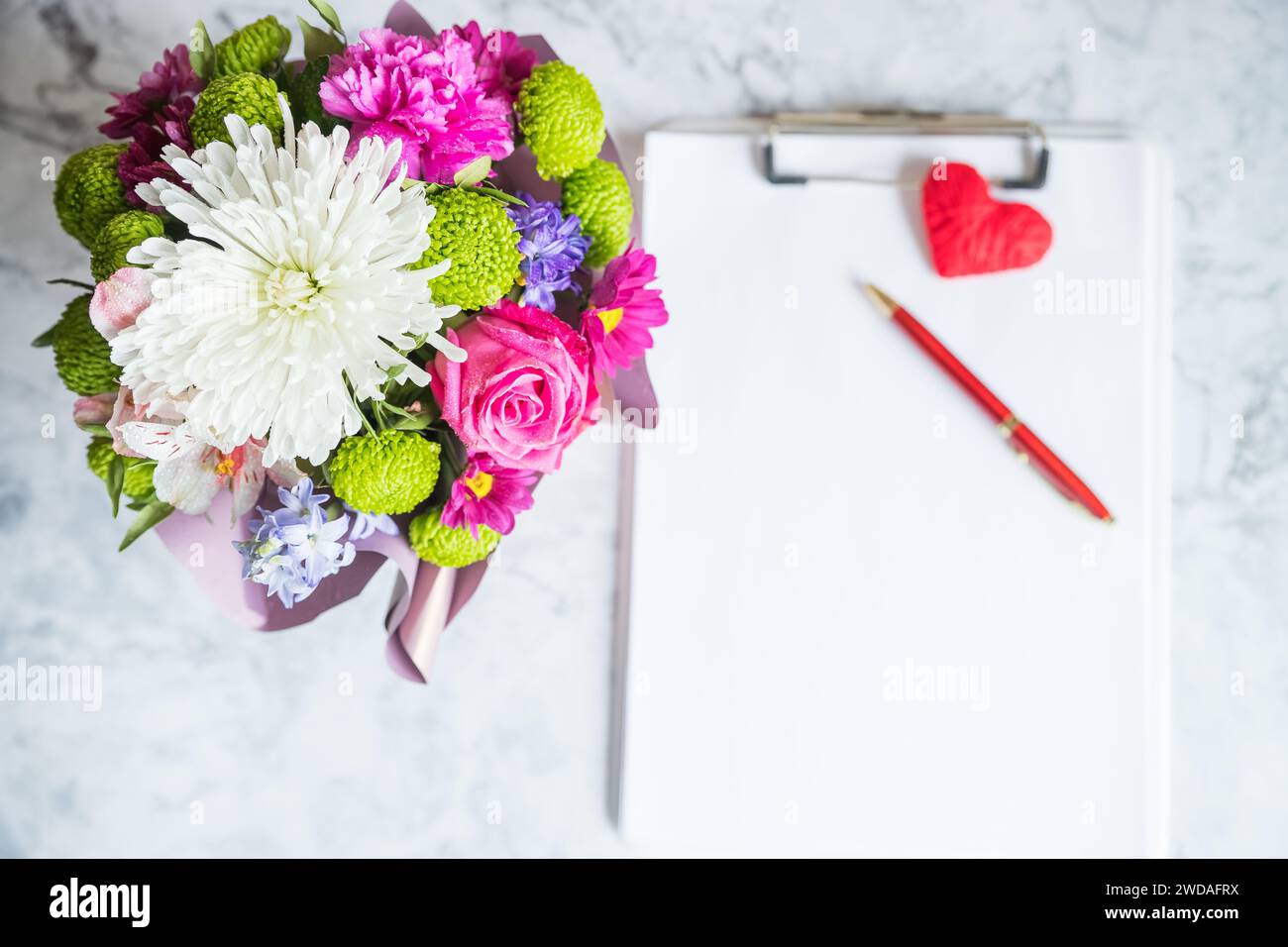Bouquet of red roses and an envelope with a note on a white back Stock ...