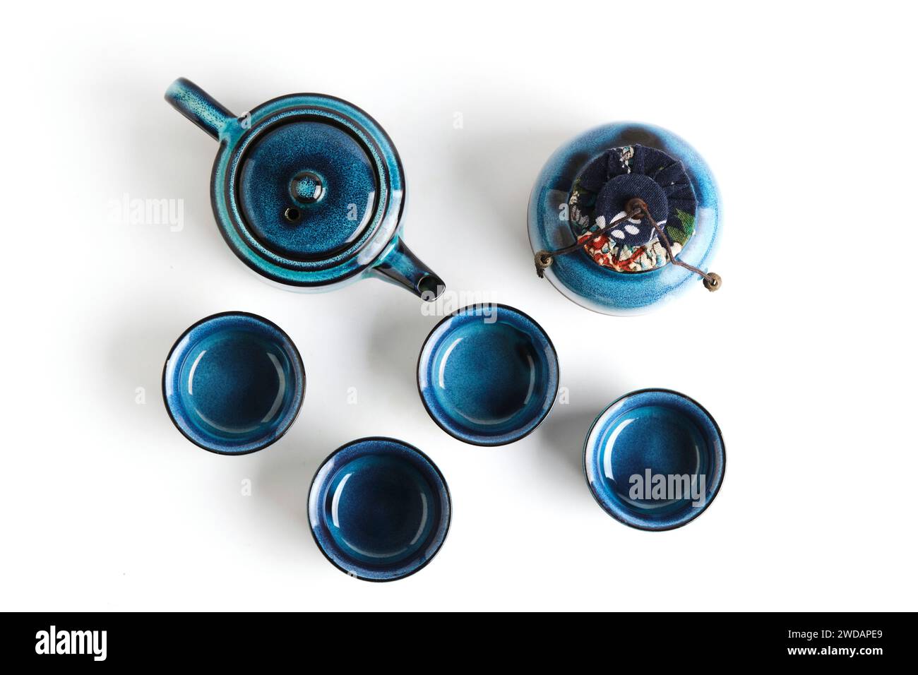 Tea set on a white background: an elegant teapot surrounded by cups. Simplicity and style in every detail, perfect for coziness and tea time Stock Photo