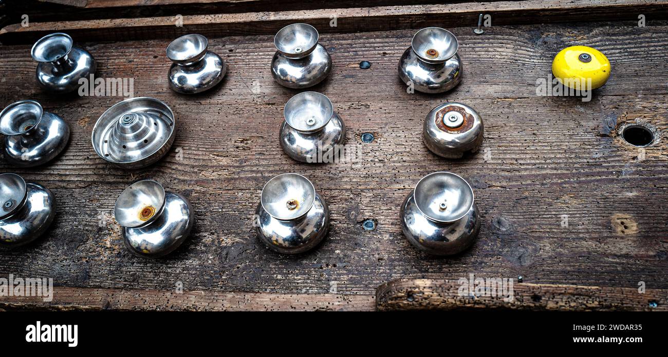 Various metal fittings placed beside a vibrant yellow toy on a wooden table Stock Photo