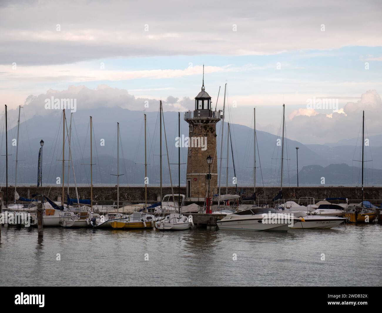 DESENZANO DEL GARDA, ITALY - SEPTEMBER 21, 2023:  View of Lighthouse (Faro di Desenzano del Garda) and boats in the harbour Stock Photo