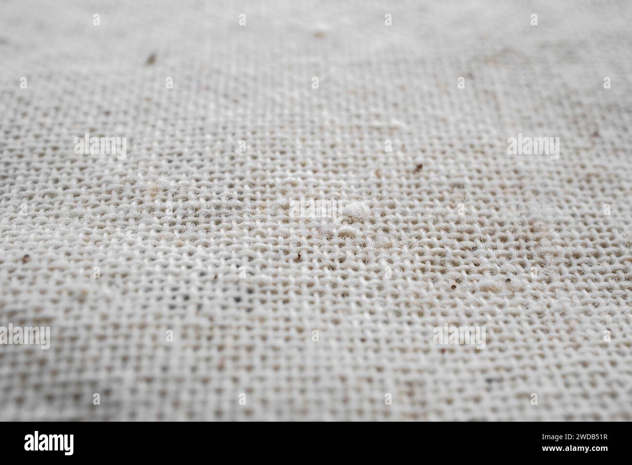 Macro detail of woven white linen natural fabric texture background, selective focus Stock Photo