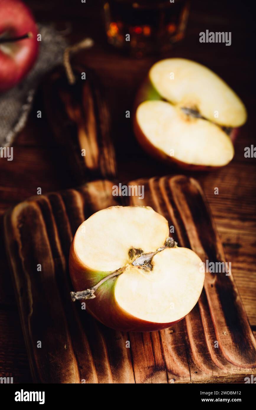 Halved Red Apple on Cutting Board in Rustic Setting Stock Photo