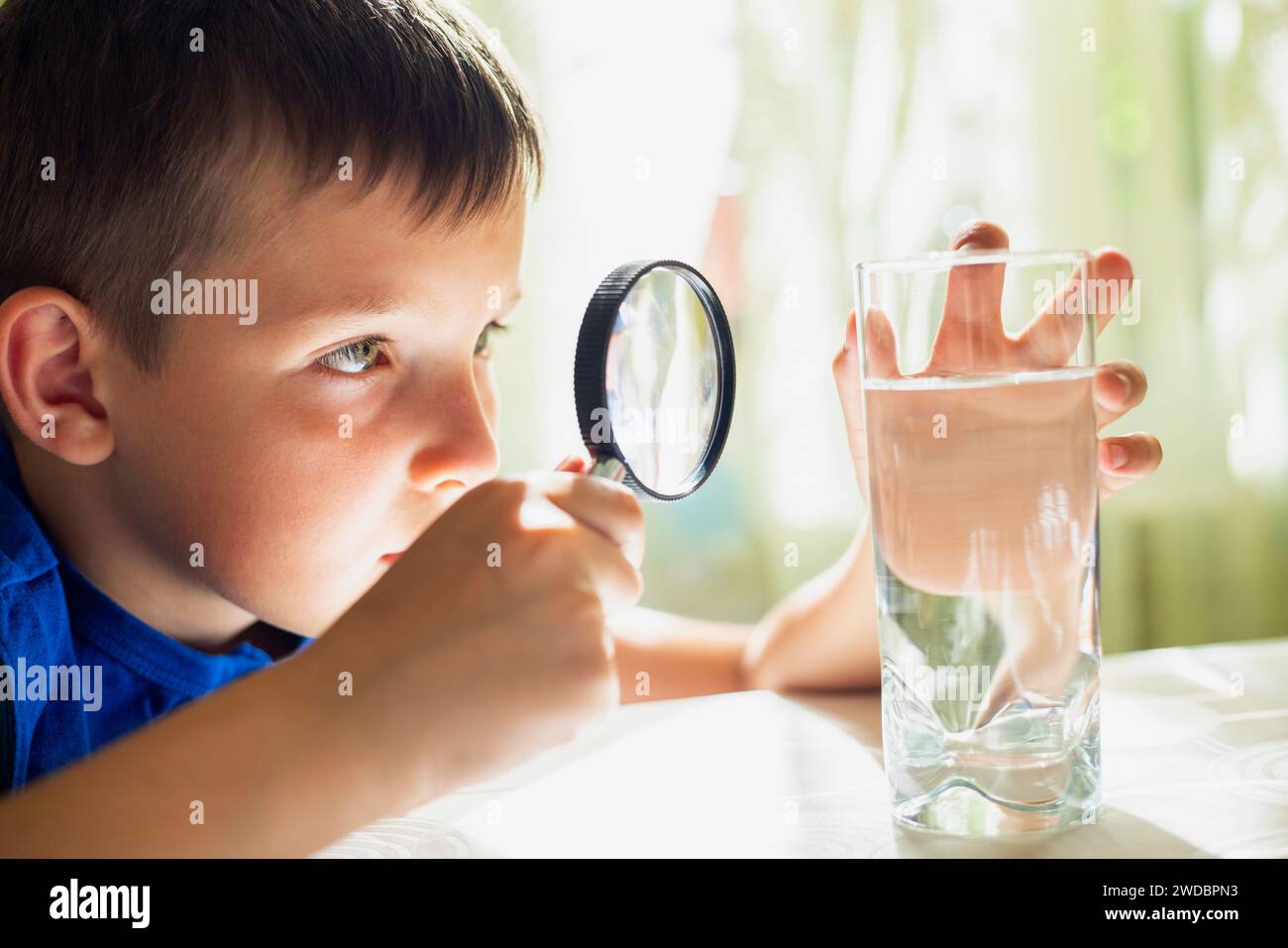 Boy Investigating Water with Magnifying Glass Stock Photo - Alamy