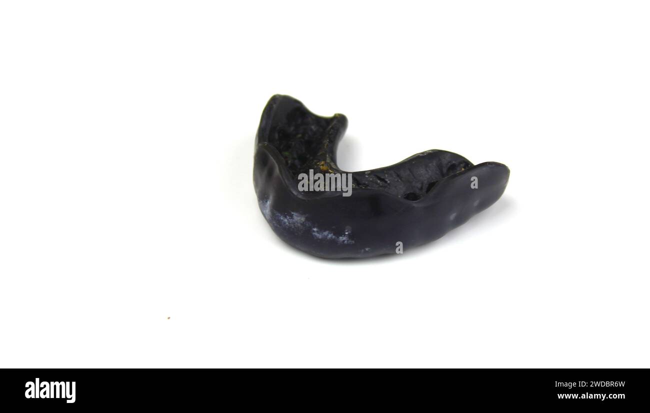 A close up photo of a black hockey mouth guard on a white surface. Stock Photo
