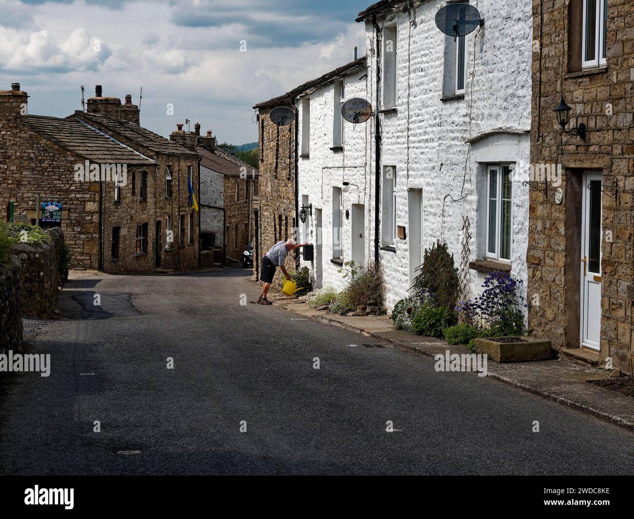 Stone houses in a tranquil village street, blue sky with clouds, a Dent