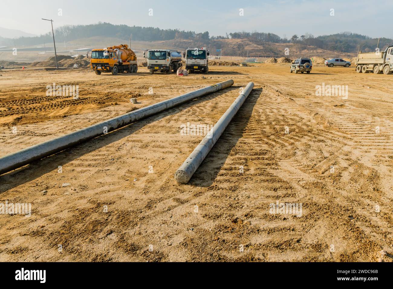 Daejeonn, South Korea, December 25, 2019: Cars and trucks parked at new construction site with utility poles on ground in foreground. For editorial Stock Photo