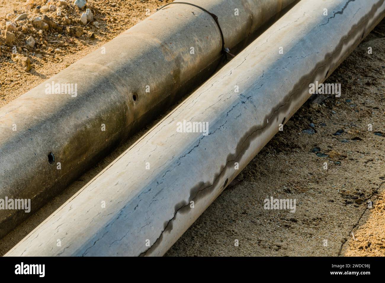 Pole In Ground Closeup of concrete utility poles laying on ground at new construction ...