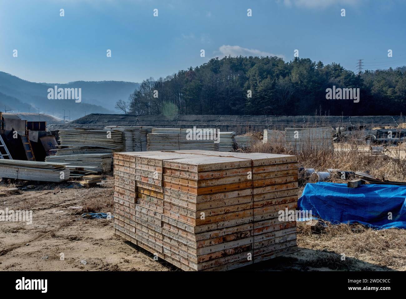 Metal concrete form sections stacked neatly at staging area for new