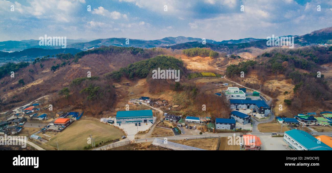 Aerial view of buildings and cars in small rural industrial community under cloudy skies, South Korea Stock Photo
