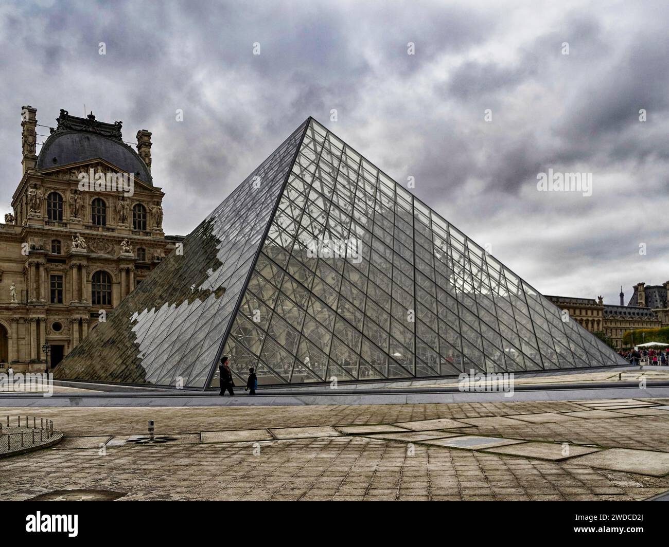 Glass pyramid of the Louvre in front of the cloudy sky as a modern ...