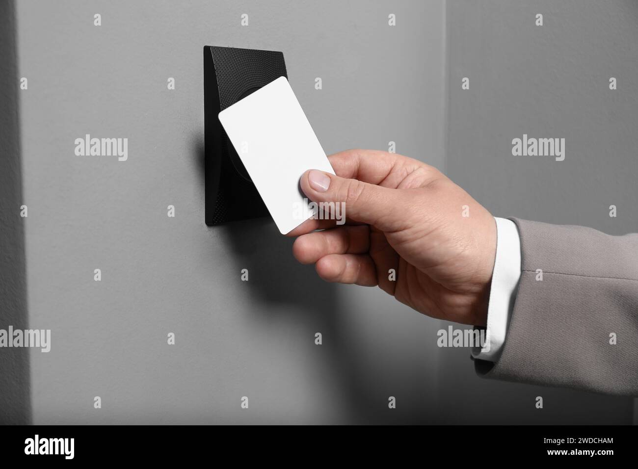 Man opening magnetic door lock with key card, closeup. Home security Stock Photo