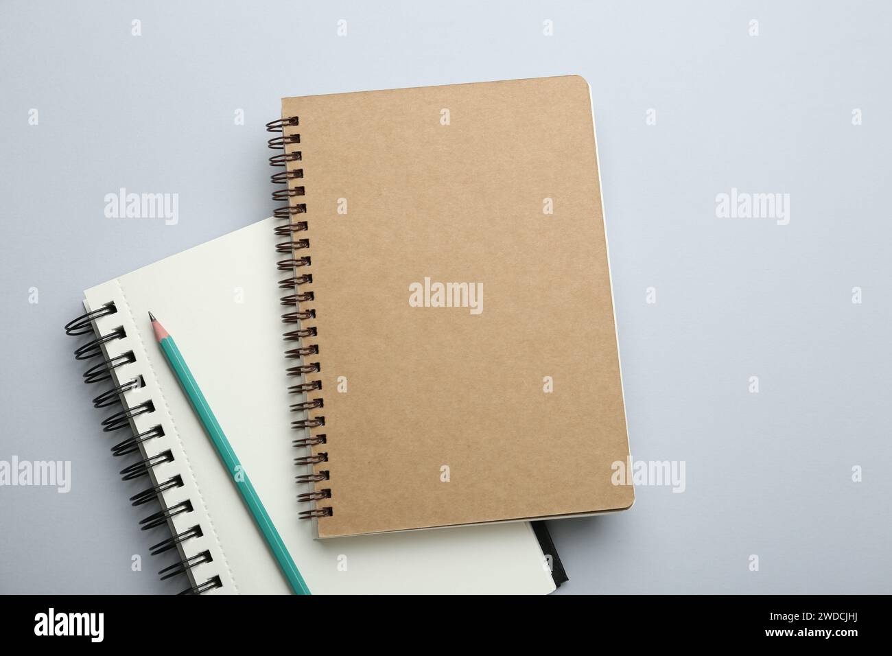 Notebooks and pencil on light grey background, top view Stock Photo