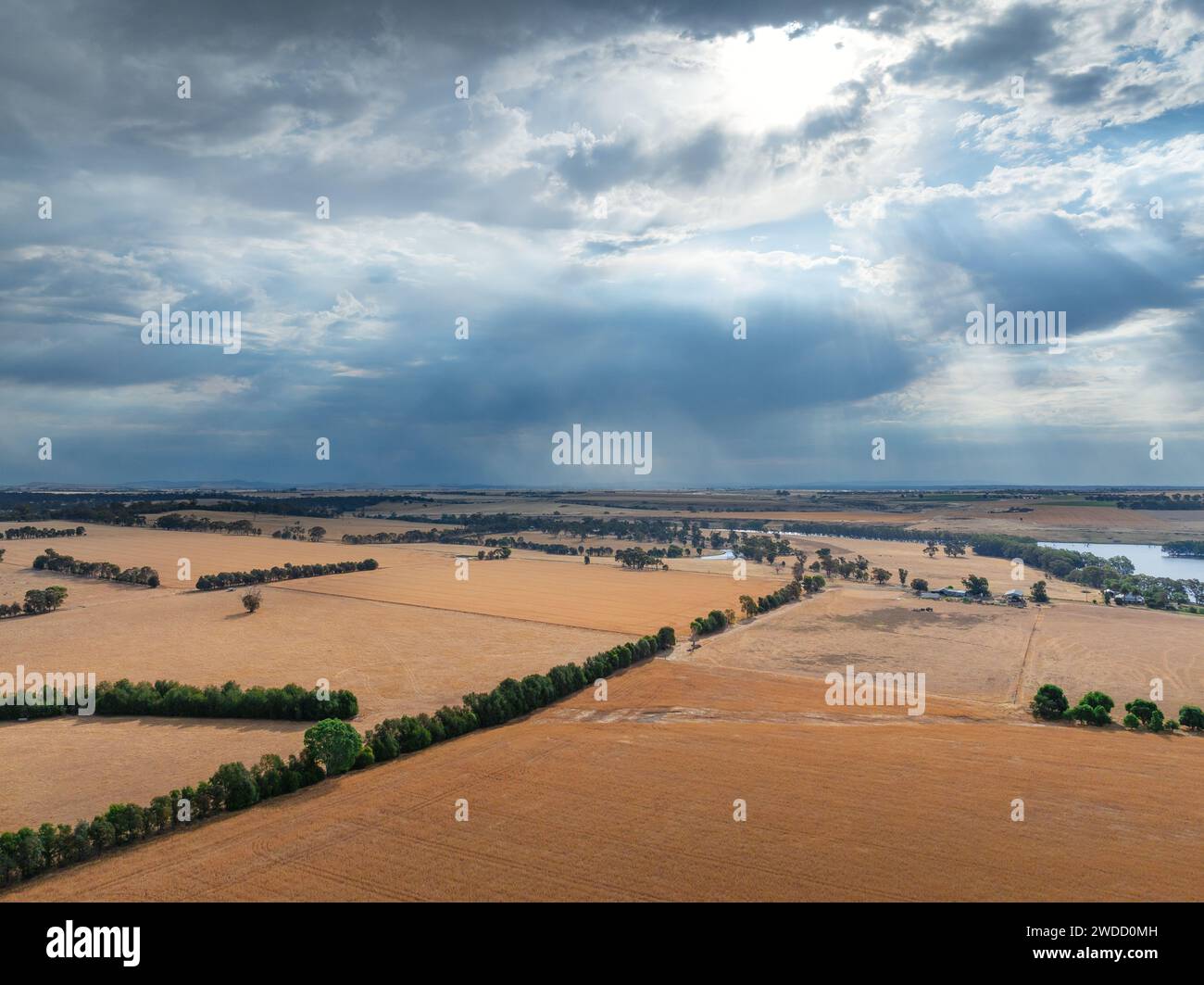 Aerial view of rain falling from dark clouds over dry farmland at Joyces Creek in Central Victoria, Australia. Stock Photo
