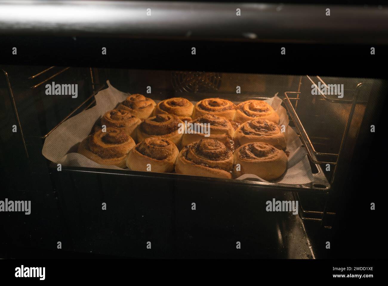 Cinnamon rolls buns baking in the oven. Stock Photo